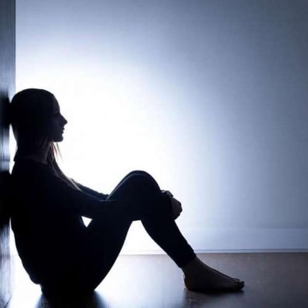 Silhouette di donna seduta, simbolo di ansia e attacco di panico. Supporto psicologico per la salute mentale.